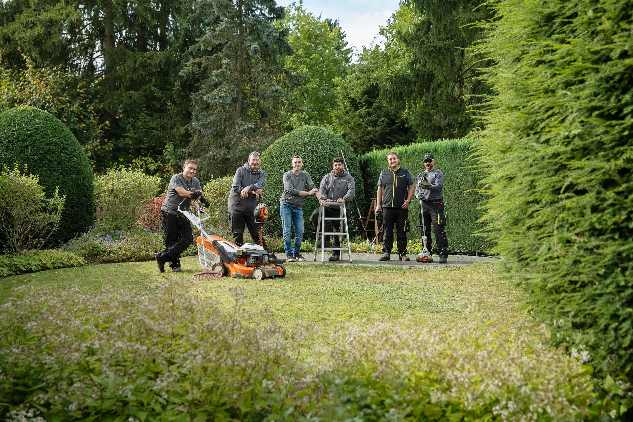 Das InFORM-Team mit Gartengeräten in einer gepflegten Gartenanlage